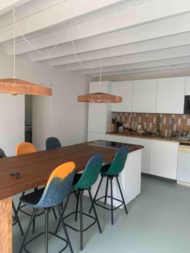 une cuisine avec une table en bois et des chaises vertes dans l'établissement Maison charmante à 15mn à pied de la mer, à Arradon