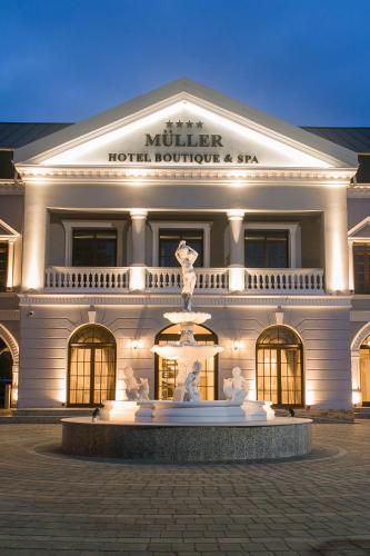 a large building with a fountain in front of it at Muller Hotel Boutique & Spa in Galaţi