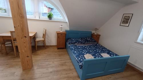 スヴォボダ・ナト・ウーポウにあるApartmány stará školaの小さなベッドルーム(青いベッド1台、テーブル付)