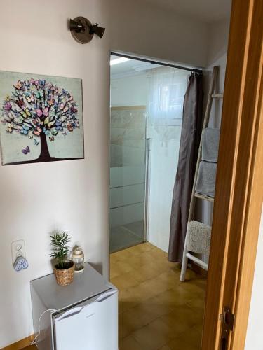 a bathroom with a shower and a tree painting on the wall at B&B Casa Mil Sueños in Ontinyent