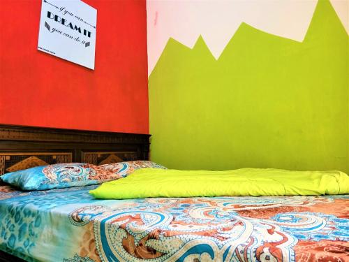 a bed in a room with a colorful wall at MG Villa in Tlekung