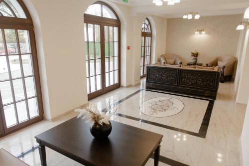 a large living room with a table and windows at Muller Hotel Boutique & Spa in Galaţi