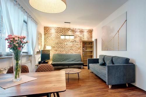 een woonkamer met een bank en een tafel bij Tyzenhauz Apartments Kazimierz in Krakau