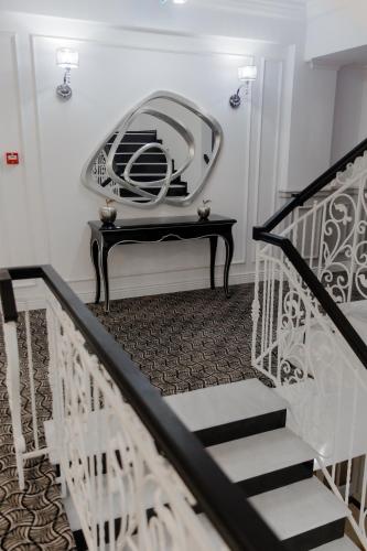 a room with a staircase with a mirror on the wall at Muller Hotel Boutique & Spa in Galaţi