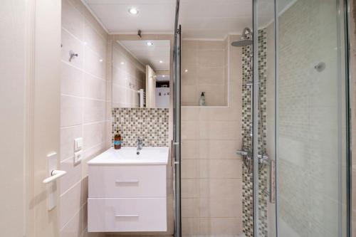 La salle de bains est pourvue d'un lavabo et d'une douche en verre. dans l'établissement Studio idéal pour deux voyageurs sur Marseille, à Marseille