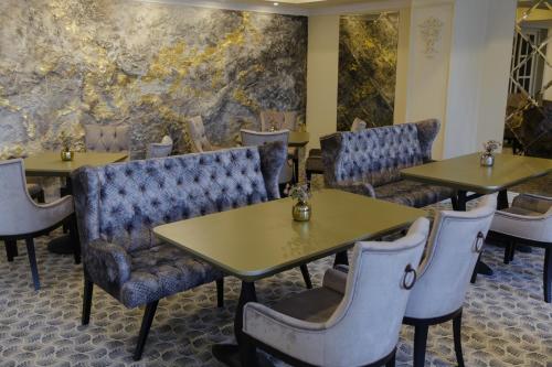 a dining room with tables and chairs and a wall at Muller Hotel Boutique & Spa in Galaţi