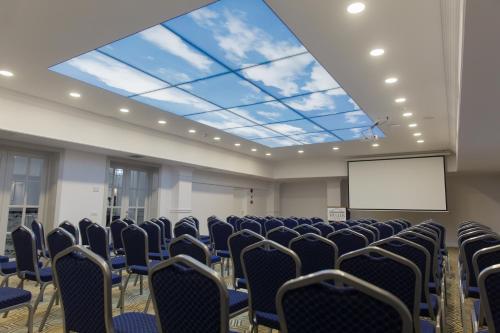 a conference room with chairs and a projection screen at Muller Hotel Boutique & Spa in Galaţi