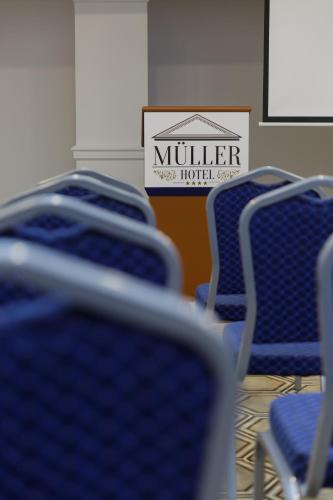a group of blue chairs with a sign in the background at Muller Hotel Boutique & Spa in Galaţi