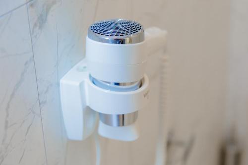 a hair dryer on a wall in a bathroom at Muller Hotel Boutique & Spa in Galaţi