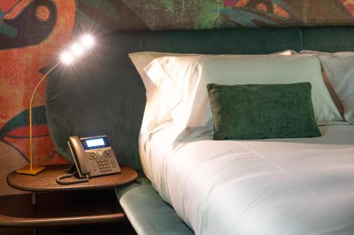 a room with a bed with a phone on a table at Atena Dolce Vita in Brescia