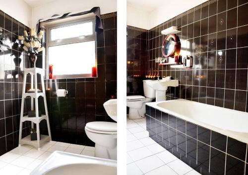 Łazienka wyłożona jest czarnymi kafelkami i dysponuje białą wanną oraz umywalką. w obiekcie Beautiful House on Wild Atlantic Way - 6 bedrooms w mieście Kenmare
