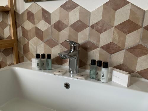 a bath tub with a sink with cosmetics on it at Sala dell Estate Guest House in Secchia