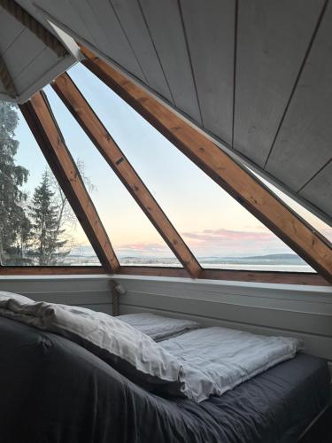 a bed in a room with a large window at Northernlight cabin in Kiruna