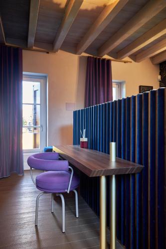 a dining room with purple chairs and a wooden table at Atena Dolce Vita in Brescia
