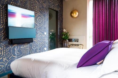 a bedroom with a bed with a flat screen tv on a wall at Atena Dolce Vita in Brescia