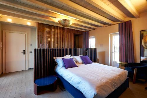 a bedroom with a large bed with purple pillows at Atena Dolce Vita in Brescia