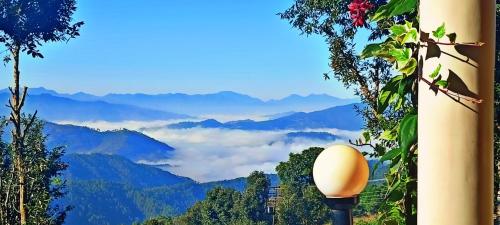 a view of a mountain valley with clouds in the distance at JMT Eco-Binsar by StayApart in Panuānaula