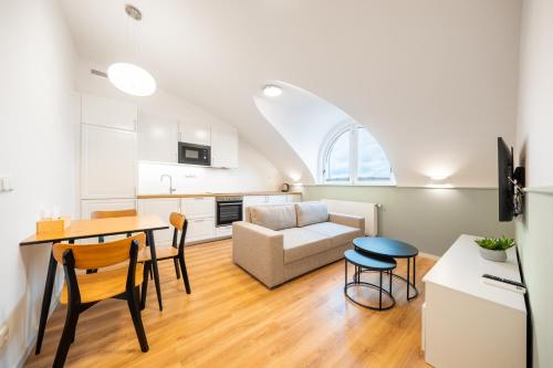 a kitchen and living room with a table and chairs at Luma Terra Prague Hostel in Prague