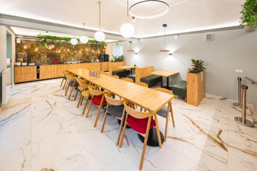 a large dining room with wooden tables and chairs at Luma Terra Prague Hostel in Prague