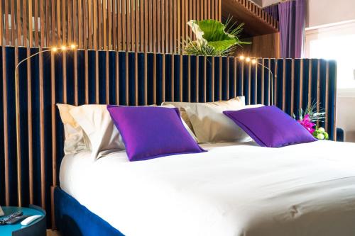 a bedroom with a large bed with purple pillows at Atena Dolce Vita in Brescia