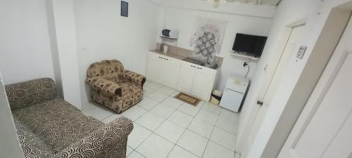 a living room with a couch and a chair at SLEEP-Inn in Scarborough