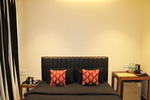 a bed with two pillows in a room at Wotel Calangute Goa in Calangute