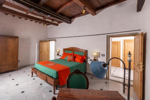 a bedroom with a bed with orange and green at IBibiena - SUITE I BIBIENA in Bibbiena