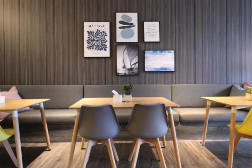 a restaurant with tables and chairs and a bench at Hualien Pink Corner Hotel in Hualien City