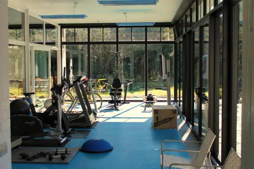 un gimnasio con suelo azul y grandes ventanas de cristal en Villa Pura Vida, en Cortrique