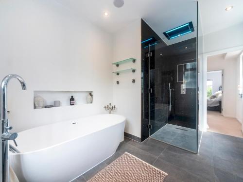 ein weißes Bad mit einer Badewanne und einer Glasdusche in der Unterkunft Pass the Keys Luxurious Flat with Large Private Terrace in Hanworth