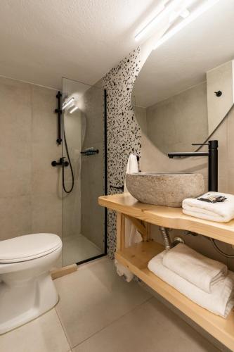a bathroom with a shower and a toilet and a sink at Haka Suites Mykonos Town in Mikonos