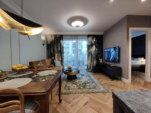 uma sala de estar com uma mesa e uma televisão em Arte Apartments - Old Town Gdańsk em Gdansk