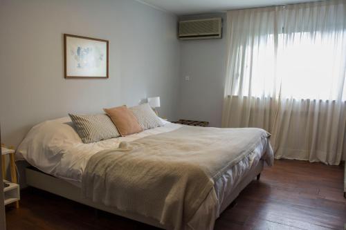 a bedroom with a large bed with a window at Casa Reconquista in Mendoza