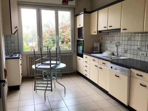 eine Küche mit weißen Schränken sowie einem Tisch und Stühlen in der Unterkunft Maison de 3 chambres avec jardin clos a Val d'Oust in La Chapelle-Caro