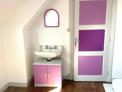 ein Bad mit einem Waschbecken und einer Tür in der Unterkunft Maison de 3 chambres avec jardin clos a Val d'Oust in La Chapelle-Caro