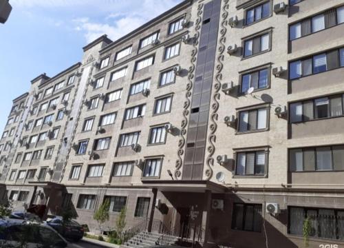 um grande edifício de apartamentos com muitas janelas em City House em Aktau