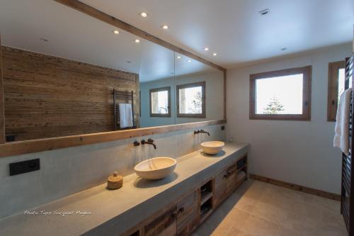 a bathroom with two sinks and a large mirror at Chalet Le Ferme Combloux Rhone-Alps in Combloux