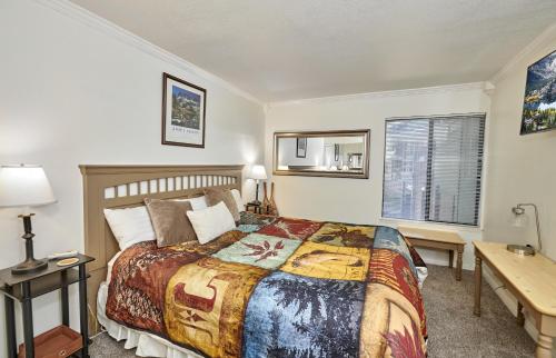 een slaapkamer met een bed, een bureau en een raam bij St Anton Condos #49 condo in Mammoth Lakes