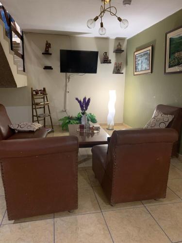 a living room with two chairs and a table at Hotel Acuario in Churín