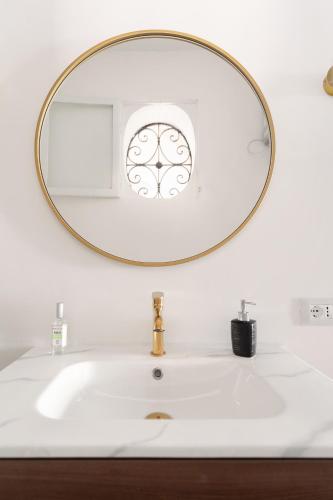 a bathroom sink with a large mirror above it at 124 Maqueda Apartments in Palermo
