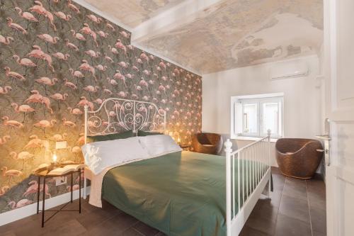 a bedroom with a bed and a wall with pink flamingos at 124 Maqueda Apartments in Palermo