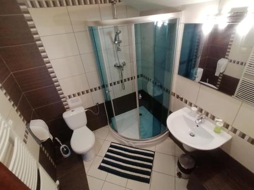 y baño con ducha, aseo y lavamanos. en Penzión Turzov en Gelnica