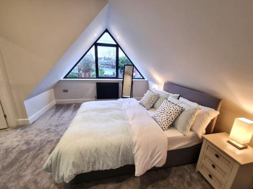 a bedroom with a large bed with a large window at Brand New, Stunning Beachside House in Seasalter