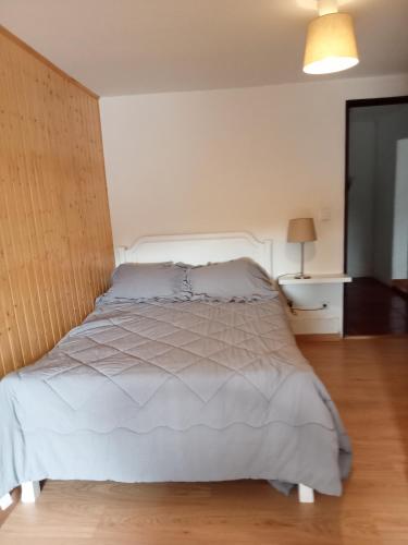 a bedroom with a white bed with a wooden floor at Casas da Nazaré2 in Ponte de Lima