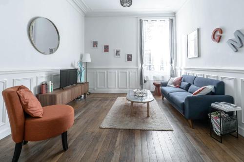 a living room with a blue couch and a mirror at Résidence Epinat II - Appartements centre - Parking in Vichy