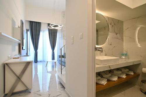 a bathroom with a sink and a mirror at Rihios Hotel in Stavros