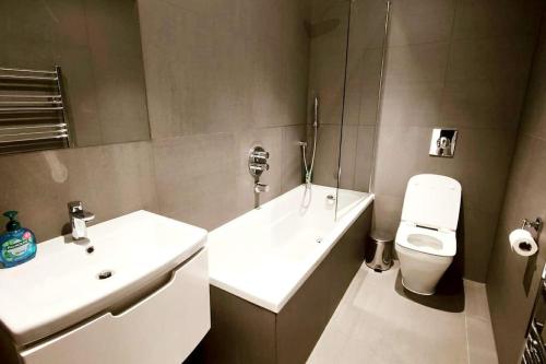 bagno con lavandino bianco e servizi igienici di Aldgate Flats in E1. a Londra