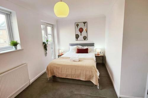 biała sypialnia z łóżkiem i 2 oknami w obiekcie Aldgate Flats in E1. w Londynie