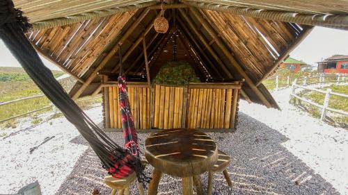 a small hut with a table and a stool in it at CÉU DE AGARTHA Retiros e Vivências in Alto Paraíso de Goiás