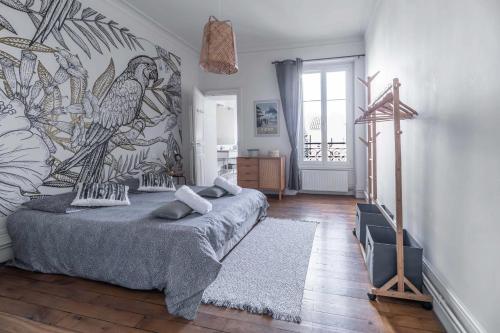 - une chambre avec un lit orné d'une fresque murale représentant les oiseaux dans l'établissement Résidence Epinat II - Appartements centre - Parking, à Vichy